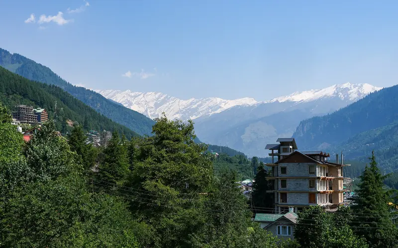 Green Manali valley with snow peaks behind
